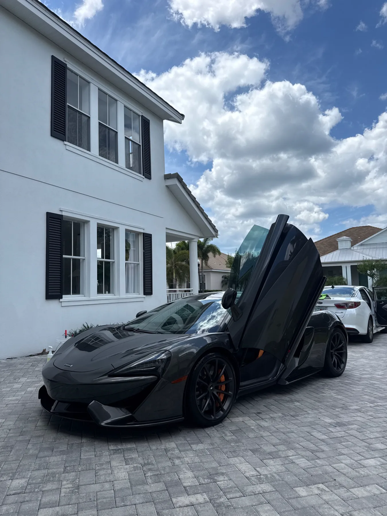Dark grey McLaren presented with its doors open