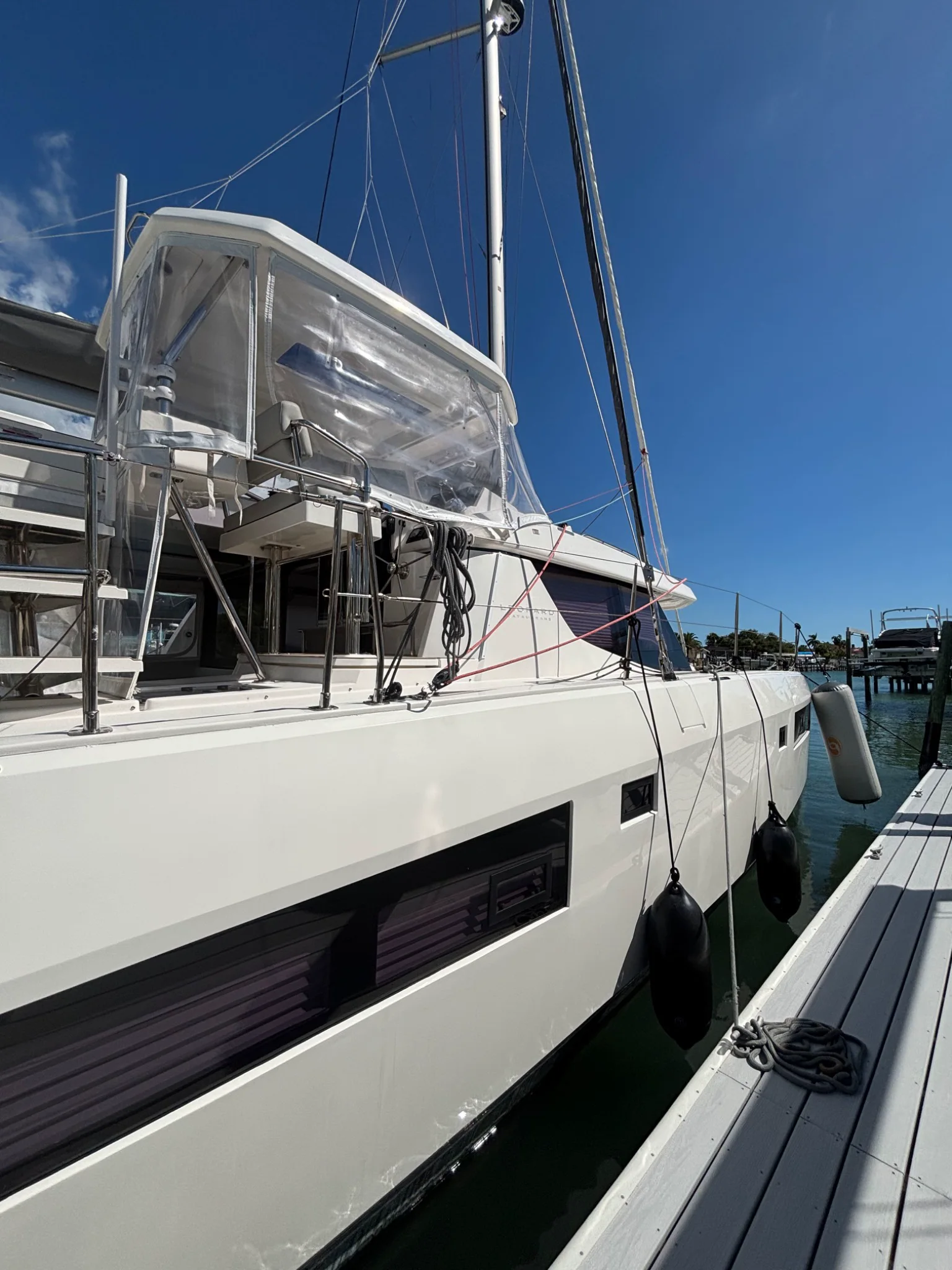 White sailing catamaran presented dockside beneath a blue sky