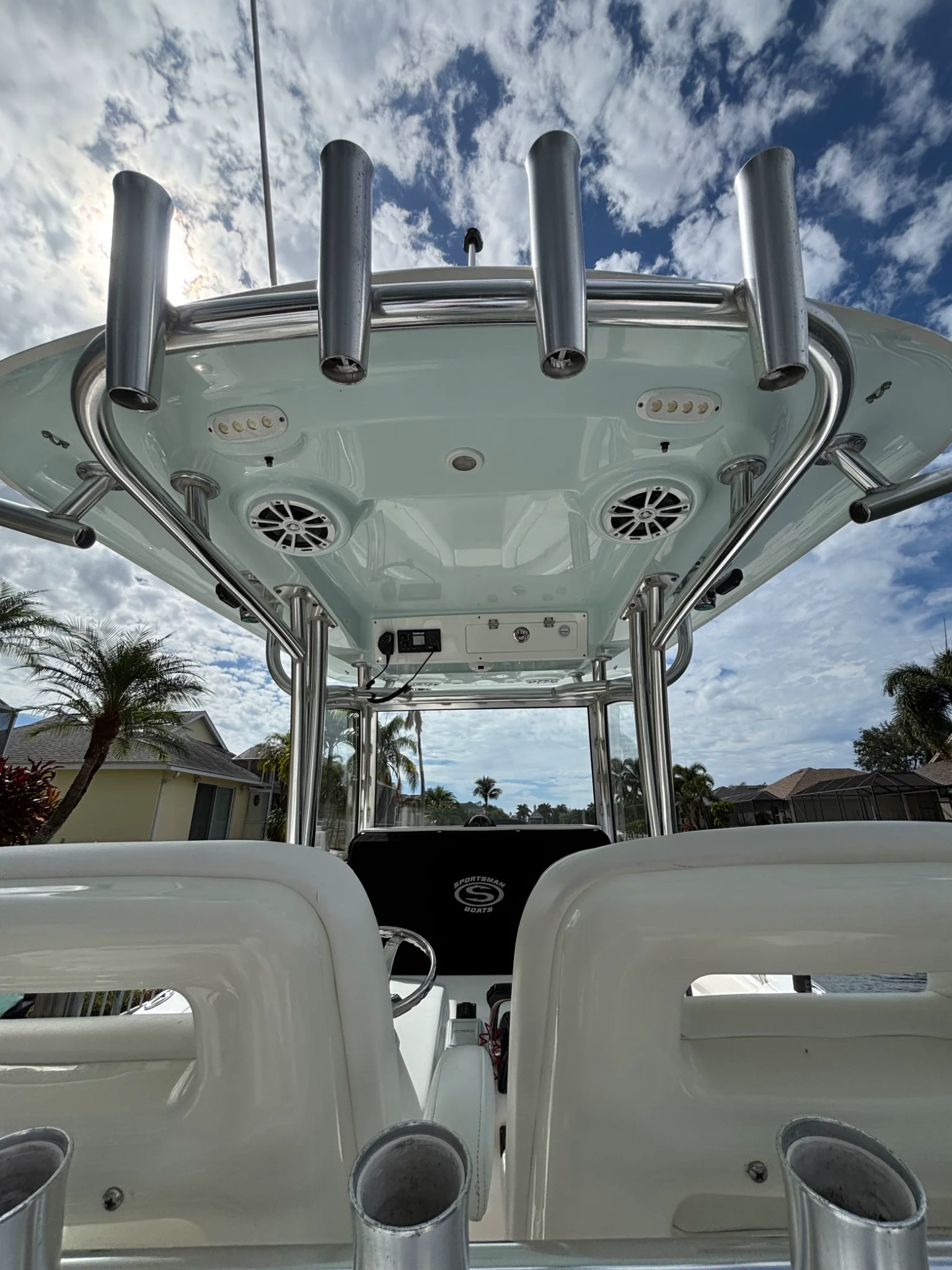 Clean white Sportsman hardtop, seating, and polished metal supports beneath a blue sky