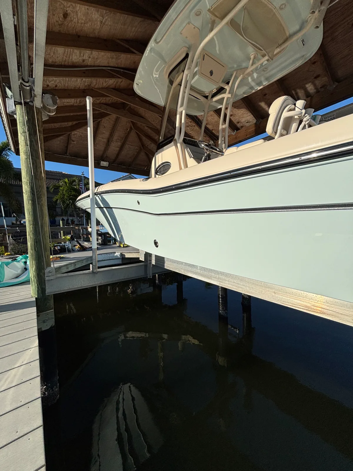 Reflective light-blue center-console hull on a waterfront lift