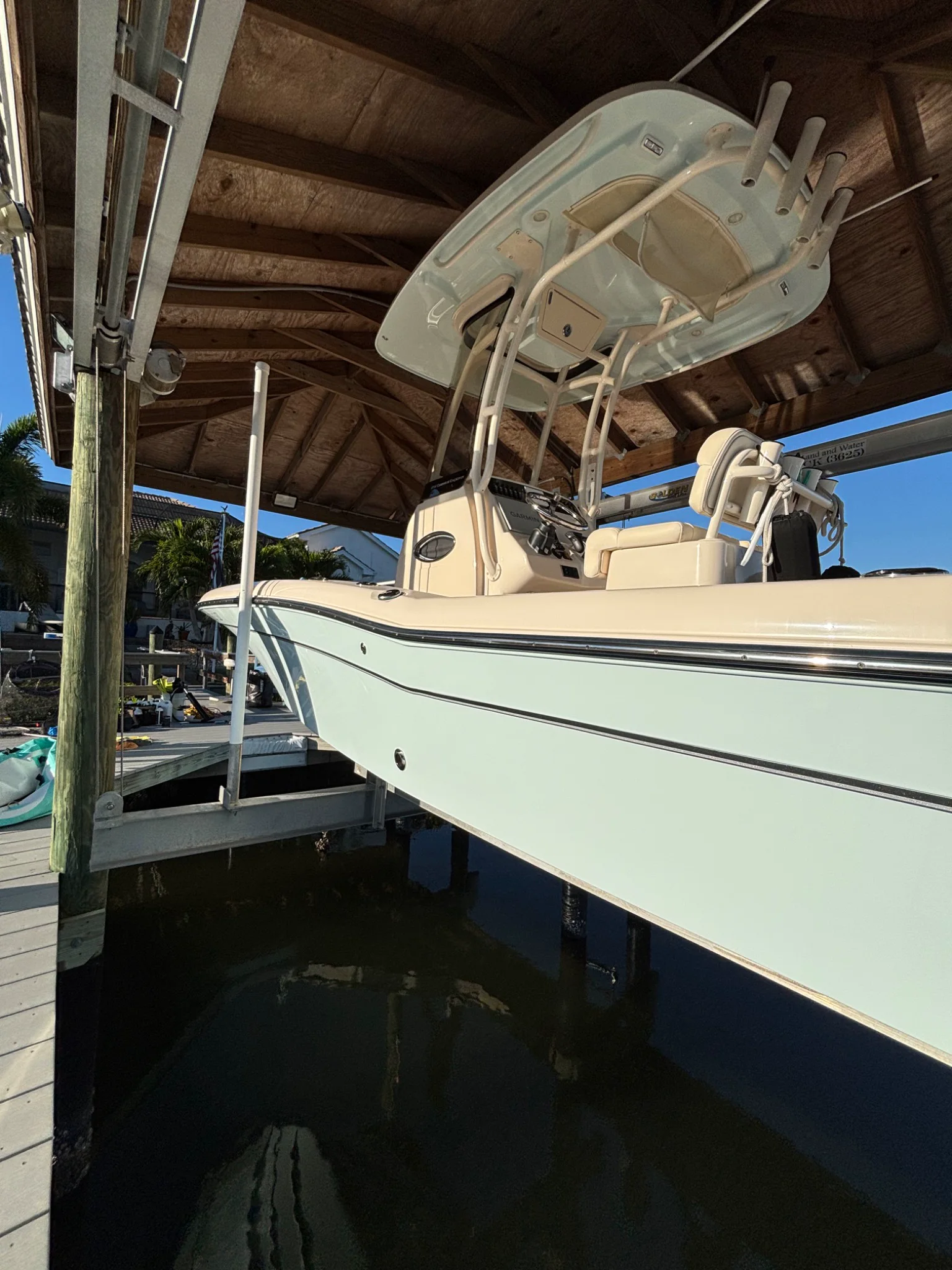 Light-blue Cobia hull and center console on a waterfront lift