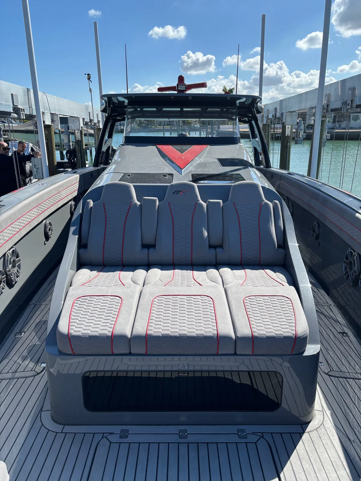 Grey marine seating with red piping and patterned stitching on a boat deck