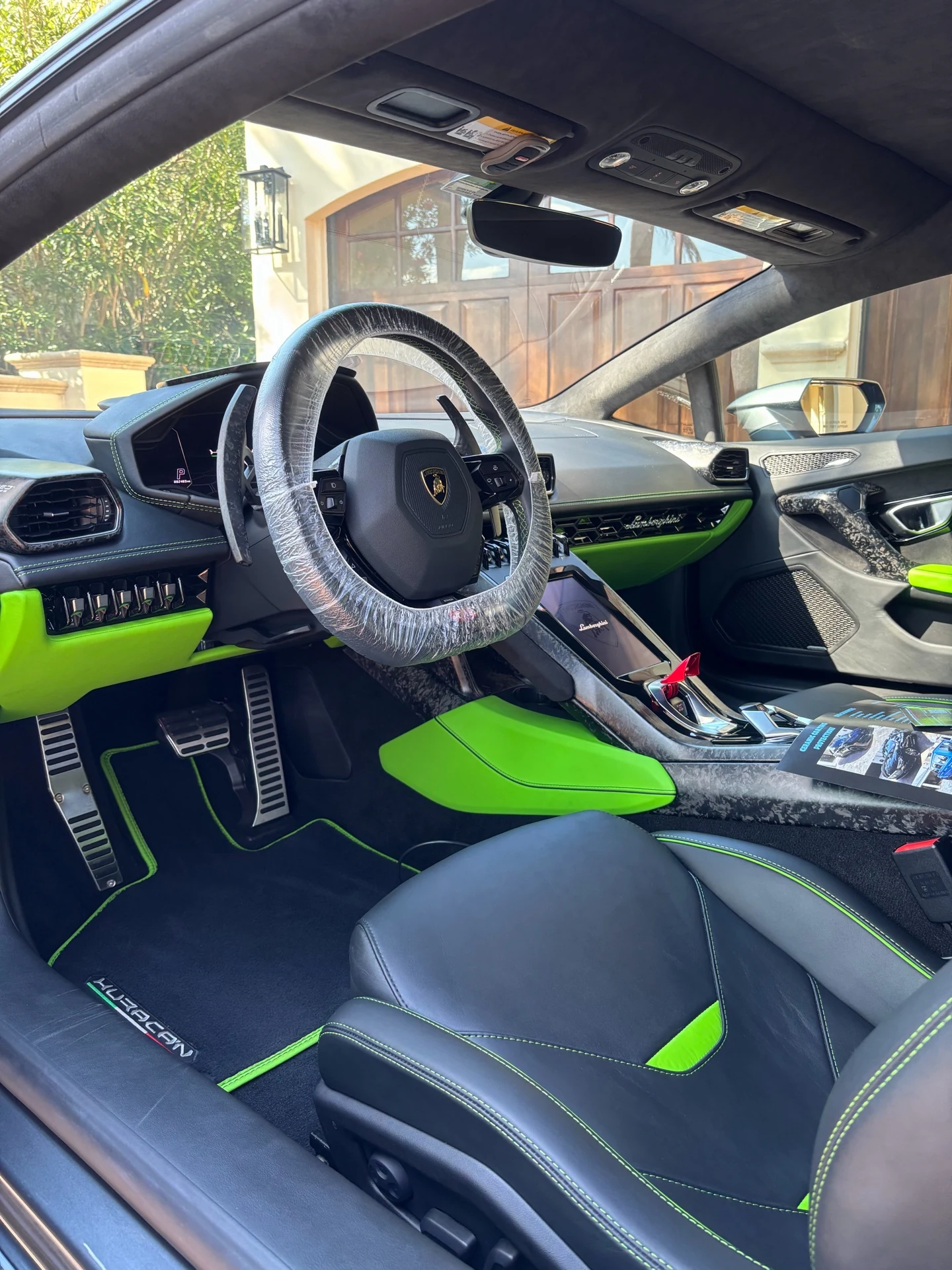 Lamborghini driver cabin with black upholstery and vivid green accents