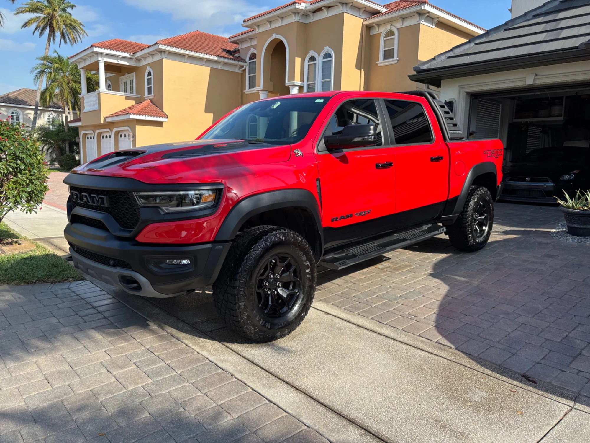 Red RAM TRX photographed from the front three-quarter angle on a residential driveway