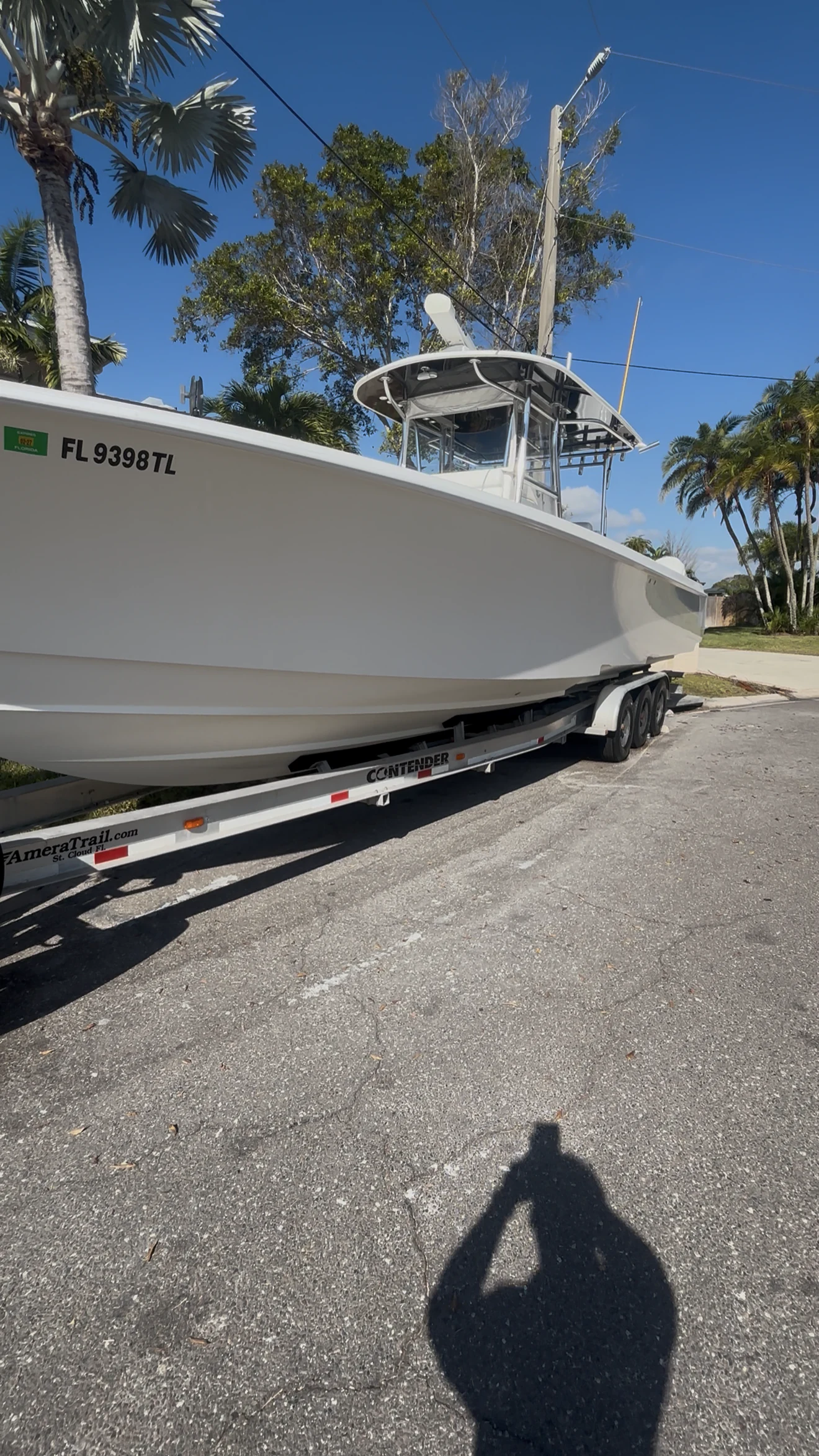 White Contender center-console boat on its trailer beneath a clear Florida sky