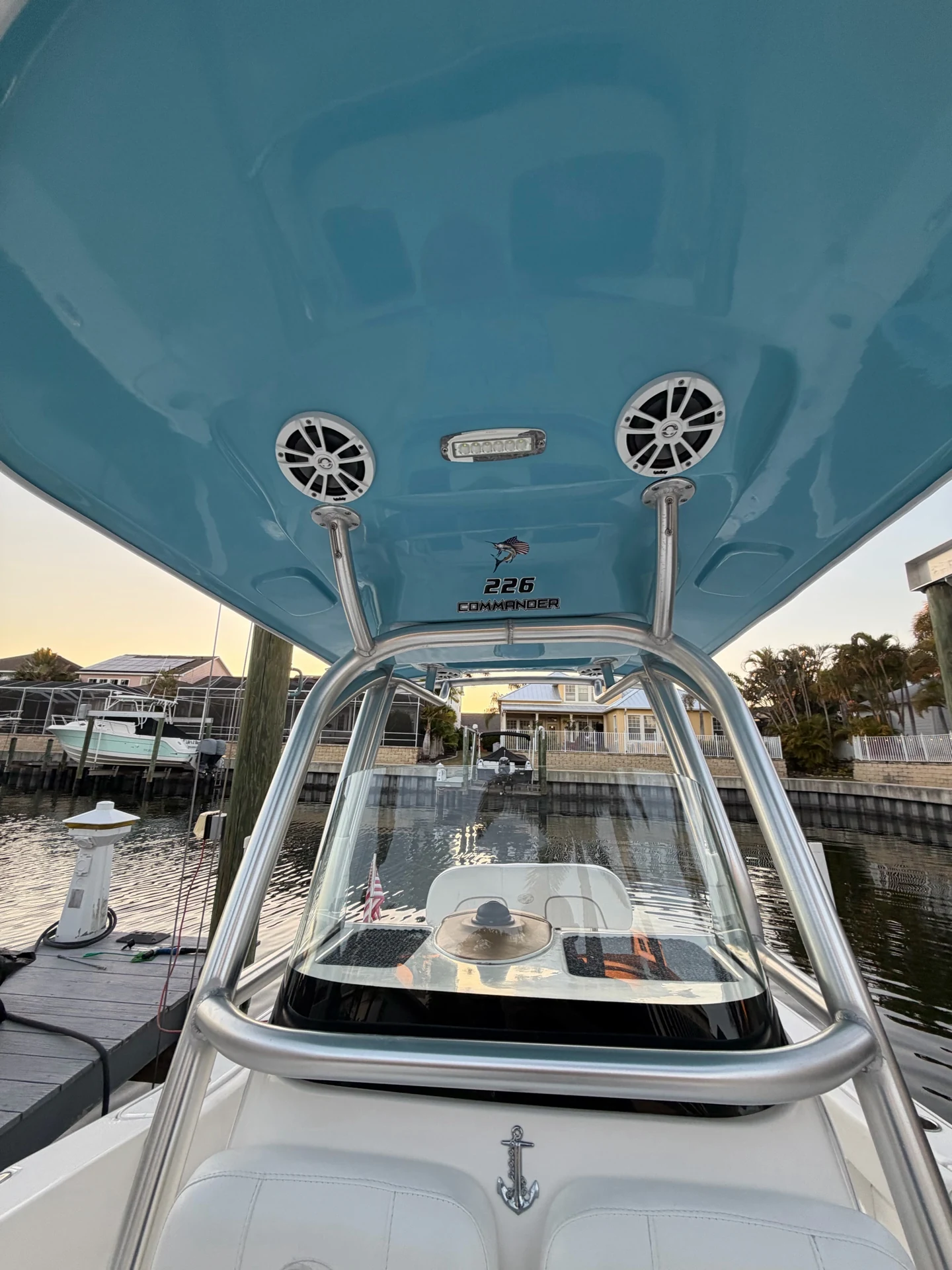 Polished metal tower supports and glossy blue hardtop underside around a clear windshield