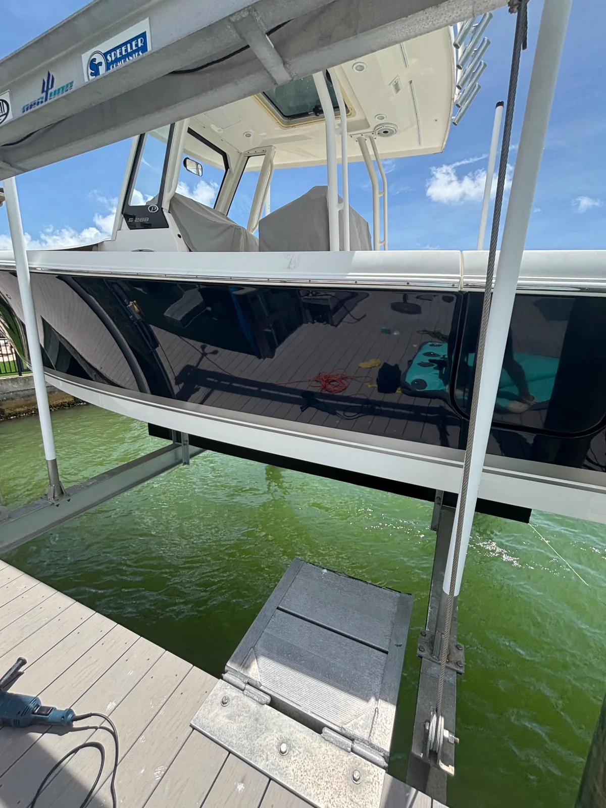 Glossy dark center-console hull presented on a waterfront lift