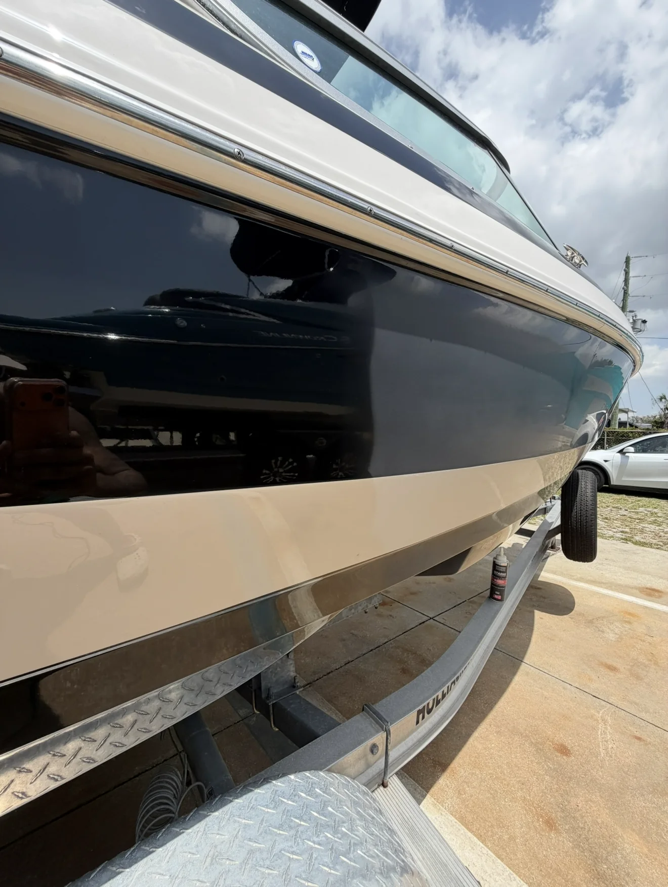 Close-up of the corrected black Regal hull reflecting the surrounding boatyard